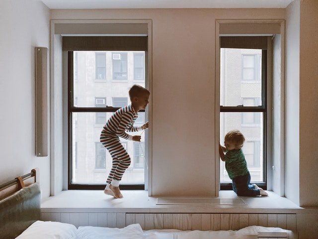 two kids playing beside glass windows 3273851 1
